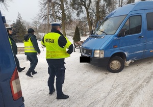 policjant i funkcjonariusz ITD stoja przed autobusem