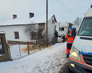 samochód wbity w ściane budynku, na poboczu stoi karetka pogotowia