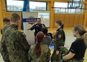 przy policyjnym stoisku policjant demonstruje używanie pałki slużbowej