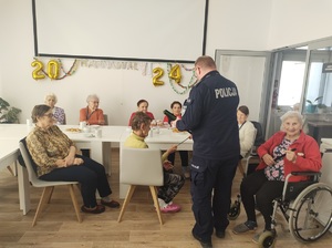 policjant rozdaje uczestnikom opaski odblaskowe