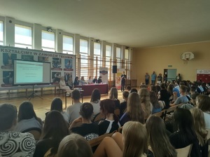 policjantka prowadzi debatę, uczestnicy siedza na lawkach