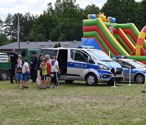 uczestnicy pikniku stoja przy radiowozach i rozmawiaja z funkcjonariuszami