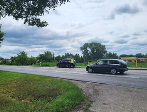 policjant stoi przy kontrolowanym pojeżdzie