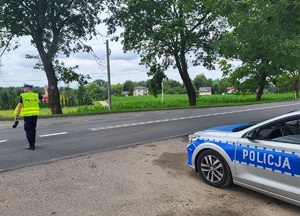 policjant na drodze daje znak do zatrzymania pojazdu