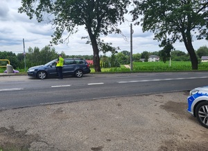 policjant stoi przy kontrolowanym pojeżdzie