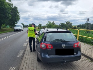 policjant stoi przy kontrolowanym pojeżdzie