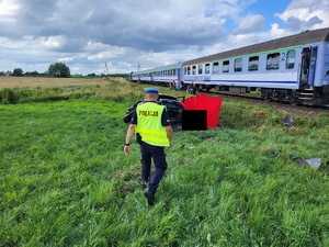 policjant podchodzi do uszkodzonego samochodu