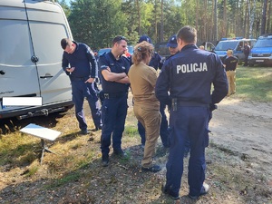 policjanci stoją i rozmawiają przy samochodzie