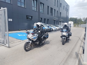 dwóch policjantów na motocyklach wyjeżdża z siedzyby policji