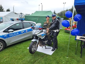 stoisko policyjne przy którym stoja mieszkaćy, na zdjęciu motocykl, radiowód