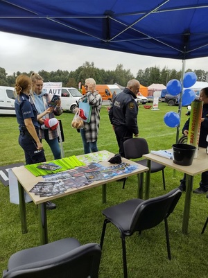 osoby rozmawiaja z policjantka przy stpoisku