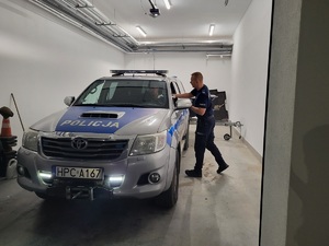 policjanci stoja przy radiowozie i przygotowuja sprzęt