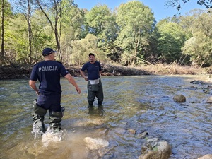 policjanci w gumowych butach chodza po wodzie