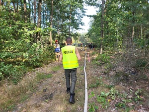 policjant kieruje się strone pożaru