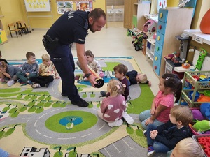 policjant rodaje dzieciom odblaski