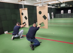 policjanci w pozycji kleczącej oddaja strzały zza przesłony