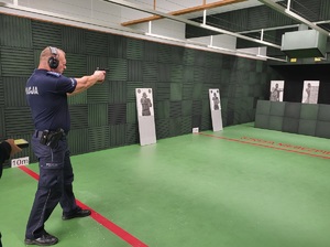 policjant w pozycji stojącej oddaje strzał