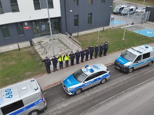 zdjecie z wysokości, policjanci stoja na chodniku i oddaja honor