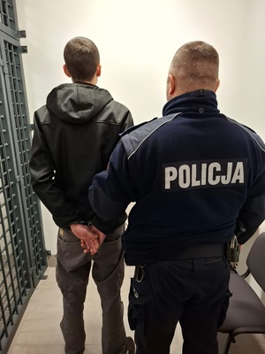 policjant stoi z zatrzymanym