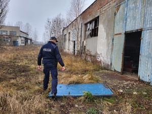 policjant idzie w kierunku opuszczonego budynku