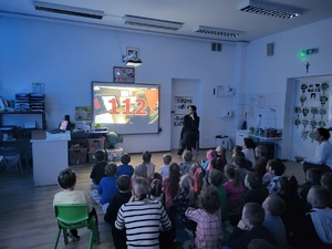 policjantka prezentuje film na tablicy dzieciom