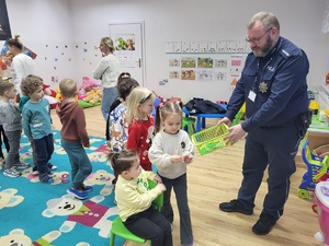 policjant rozdaje dzieciom odblaski