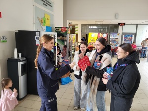 policjantka rozdaje wolontariuszom odblaski