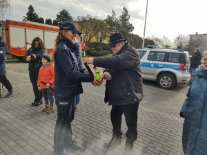 policjantka rozdaje uczestnikom odblaski