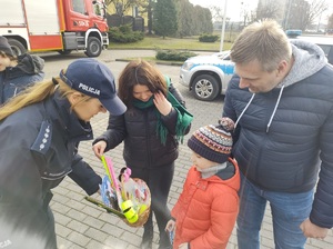 policjantka rozdaje odblaski uczestnikom wydarzenia