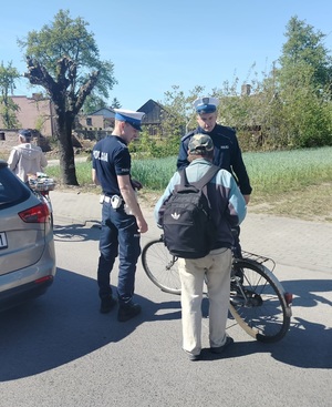 dwóch policjantów kontroluje rowerzystę