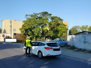 policjant podchodzi do zatrzymanego pojazdu na drodze