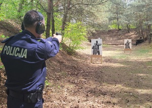 policjant kieruje broń w kierunku dwóch tarcz