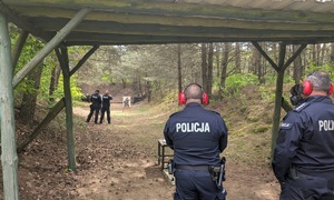 na zdjeciu znajduje się czterech policjantów, dwóch na stanowisku strzeleckim, dwóch przy tarczach