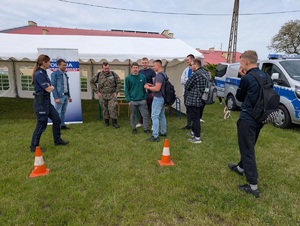 policjantka stoi przy policyjnym stoisku i rozmawia z uczestnikami
