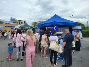 uczestnicy pikniku stoja przy policyjnym stoisku