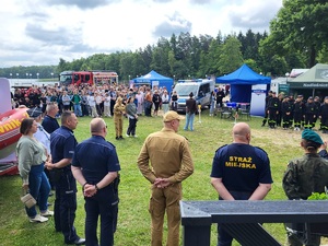 przedstawiciele słuzb stoją przed zebranymi dziecmi