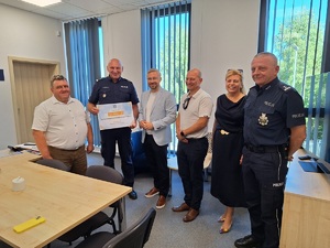 na zdjeciu 6 osób, starosta przekazuje symboliczny czek, na którym widnieje na pis czek na kwotę 20.000 dla Komendy Powiatowej Policji w Rypinie,  Starosta Rypiński, Zarząd i Rada Powiatu w Rypinie