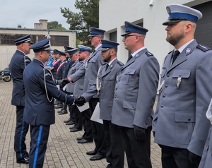 z-ca komendanta wojewódzkiego policji w Bydgoszczy z komendantem powiatowym policji w rypinie podchodzą do stojących policjantów i wręczaja im akty mianowania, składając przy tym homor