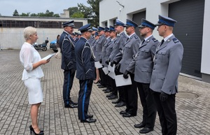 z-ca komendanta wojewódzkiego policji w Bydgoszczy z komendantem powiatowym policji w rypinie podchodzą do stojących policjantów i wręczaja im akty mianowania, składając przy tym homor
