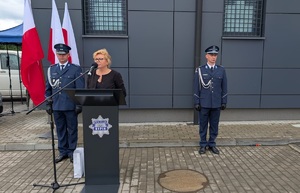 na mównicy stoi Wicestarostwa Rypiński Monika kalinowska, po obu stronach stoja policjanci z tyłu stoi stojak z flagami rzeczypospolitej Polskiej