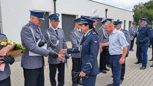 na zdjeciu 9 policjantów, jedna osoba cywilna, wszystcy skąłdają sobie zyczenia