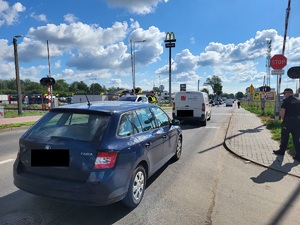policjant stoi na drodze na przejeździe kolejowym