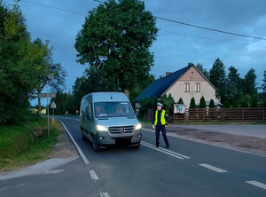 policjant na drodze podchodzi do zatrzymanego pojazdu