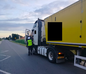 policjant sprawdza stan trzexwości kierowcy cięzarówki