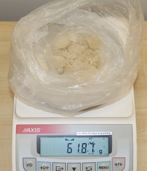 worek z białymi kryształami leżący na elektronicznej wadze, na wyświetlaczu widnieje wartość 61,87 g