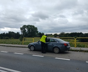 policjant stoi przy zatrzymanym pojezdzie