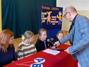 jedna osoba, trzyma mikrofon przy ustach dziewczynki