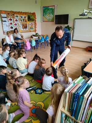 policjant chodzi wśród dzieci i prezentuje im tube