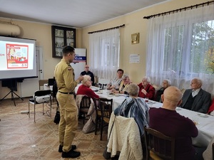 strażak stojący przed uczestnikami debaty i prowadzacy prelekcje