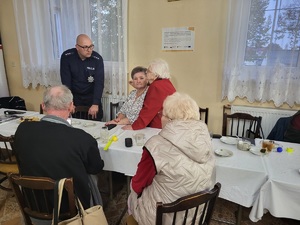 policjant stojący przy uczestnikach debaty i prowadzacy z nimi rozmowę